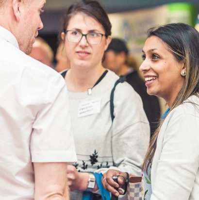 people chatting to exhibitors at conference