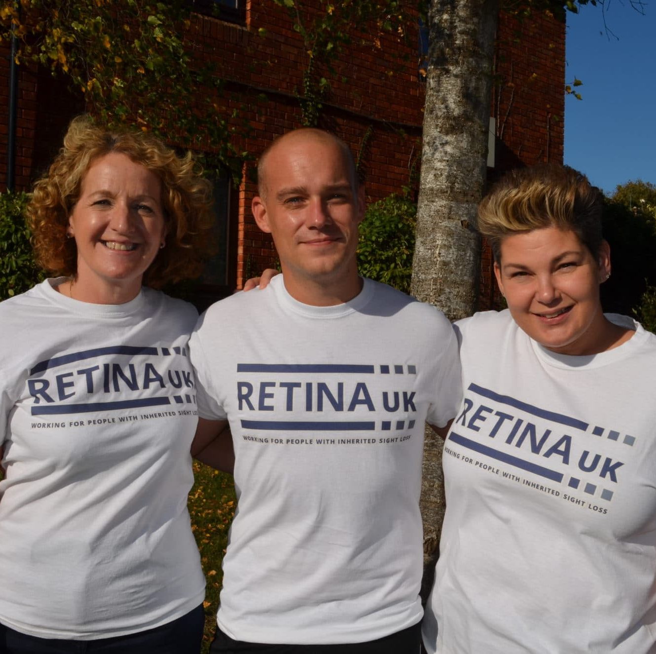 Three people smiling in Retina UK T shirts