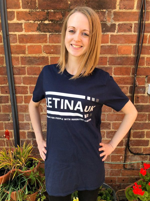 The Retina UK t-shirt shown from t he front with the Retina UK logo printed in white on a dark blue tshirt.
