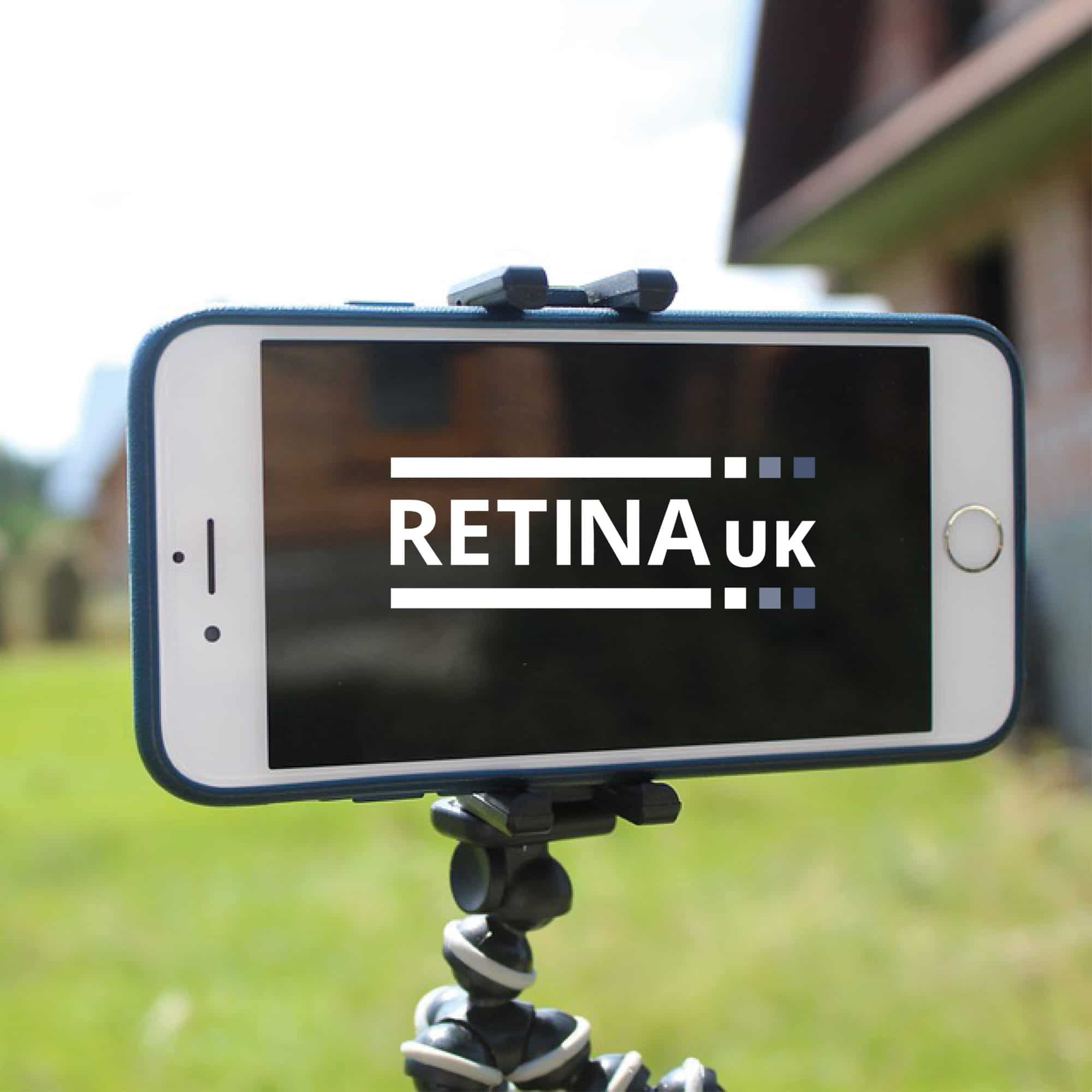 A mobile phone wiht the Retina UK logo on the screen. The phone is clamped into a tripod