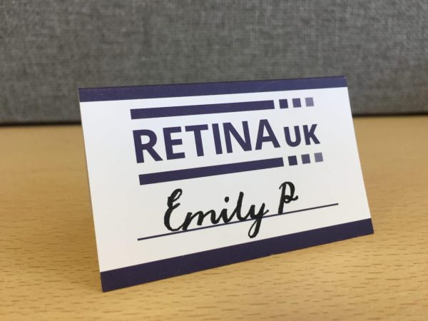 Retina UK A framed place card with the Retina UK logo and a a line to write in the name of the person. In this example the name 'Emily P' has been written in