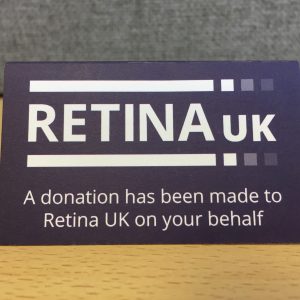 A tented card viewed straight on with the Retina UK logo and the words "A donation has been made to Retina UK on your behalf"
