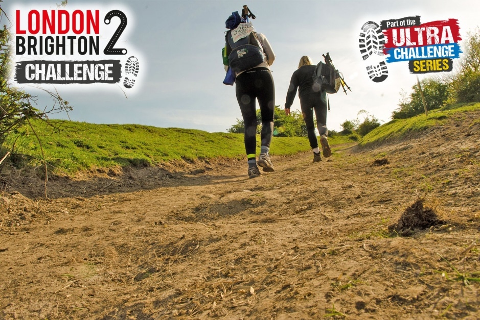 Image shows a dirt path with two people walking uphill in the distance. Text on the top left reads 'London 2 Brighton Challenge'. On the top right the image reads 'part of the ultra challenge series'
