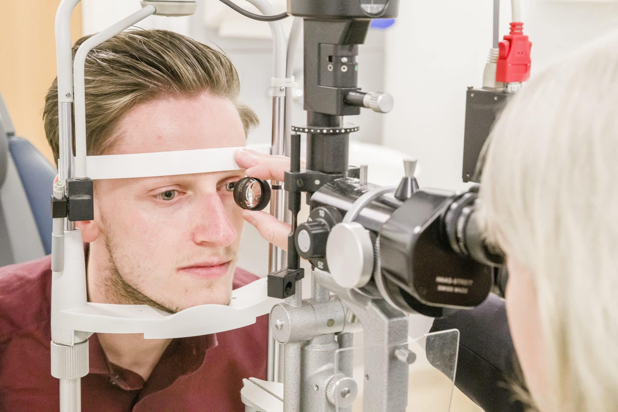 A man looking into an eye examination device