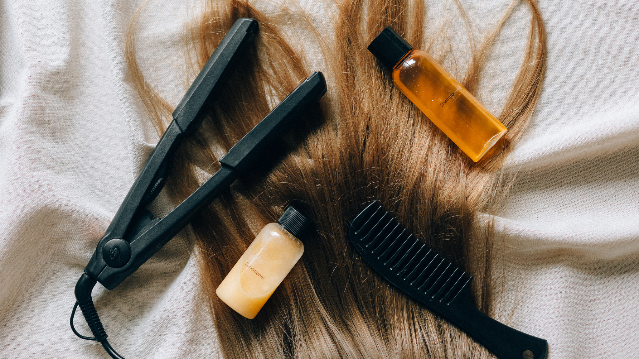 long hair with straighteners, a hairbrush and products sitting on top of it