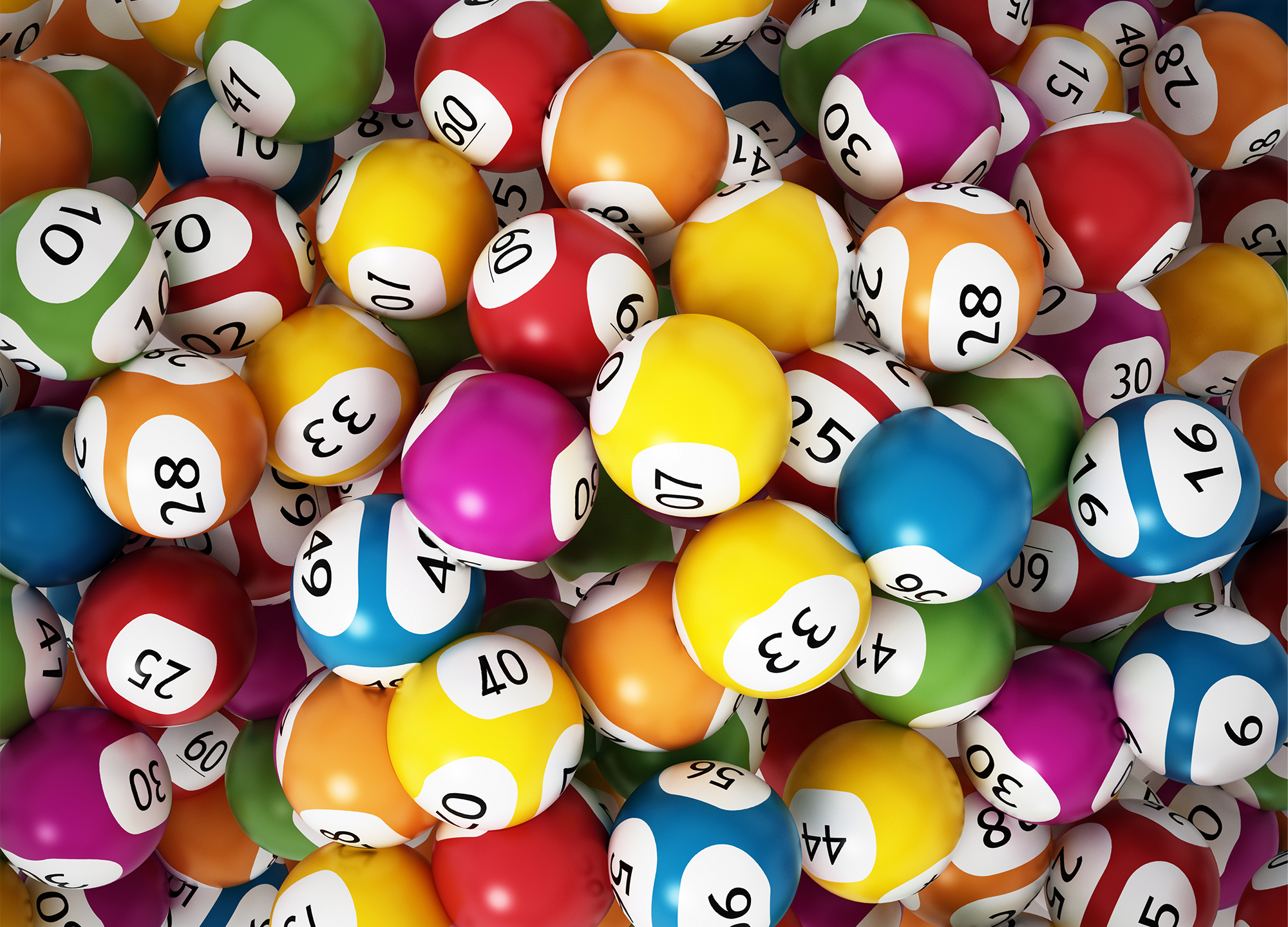 Lottery balls in lots of different bright colours with different numbers printed on them in black
