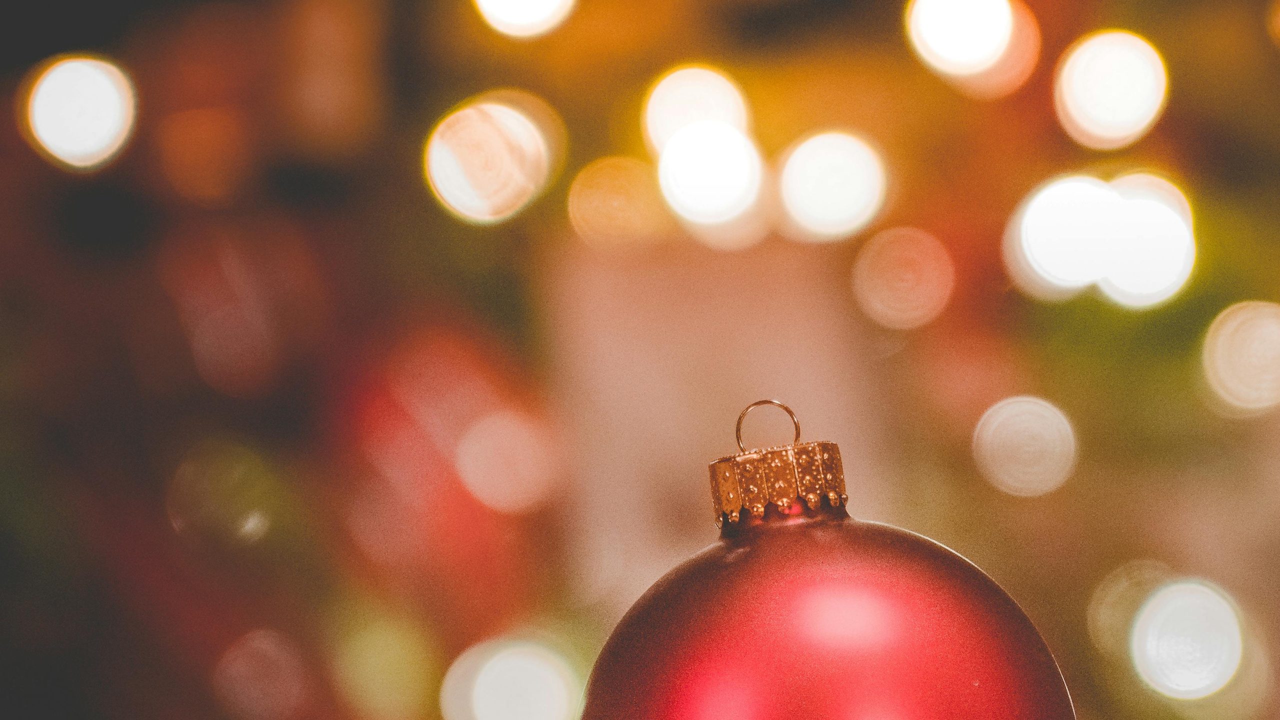 A bauble with a Christmas tree in the background.