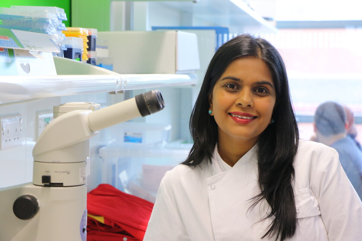 Professor Mariya Moosajee wearing a white coat in a lab