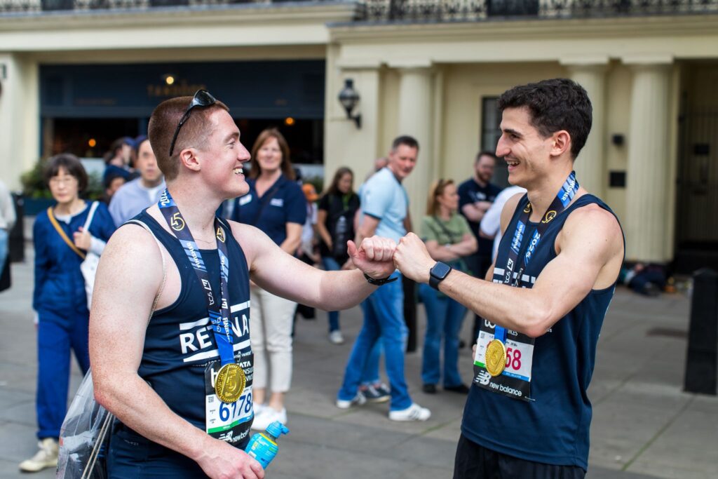 Two Retina UK runners celebrating after finishing the TCS London Marathon.