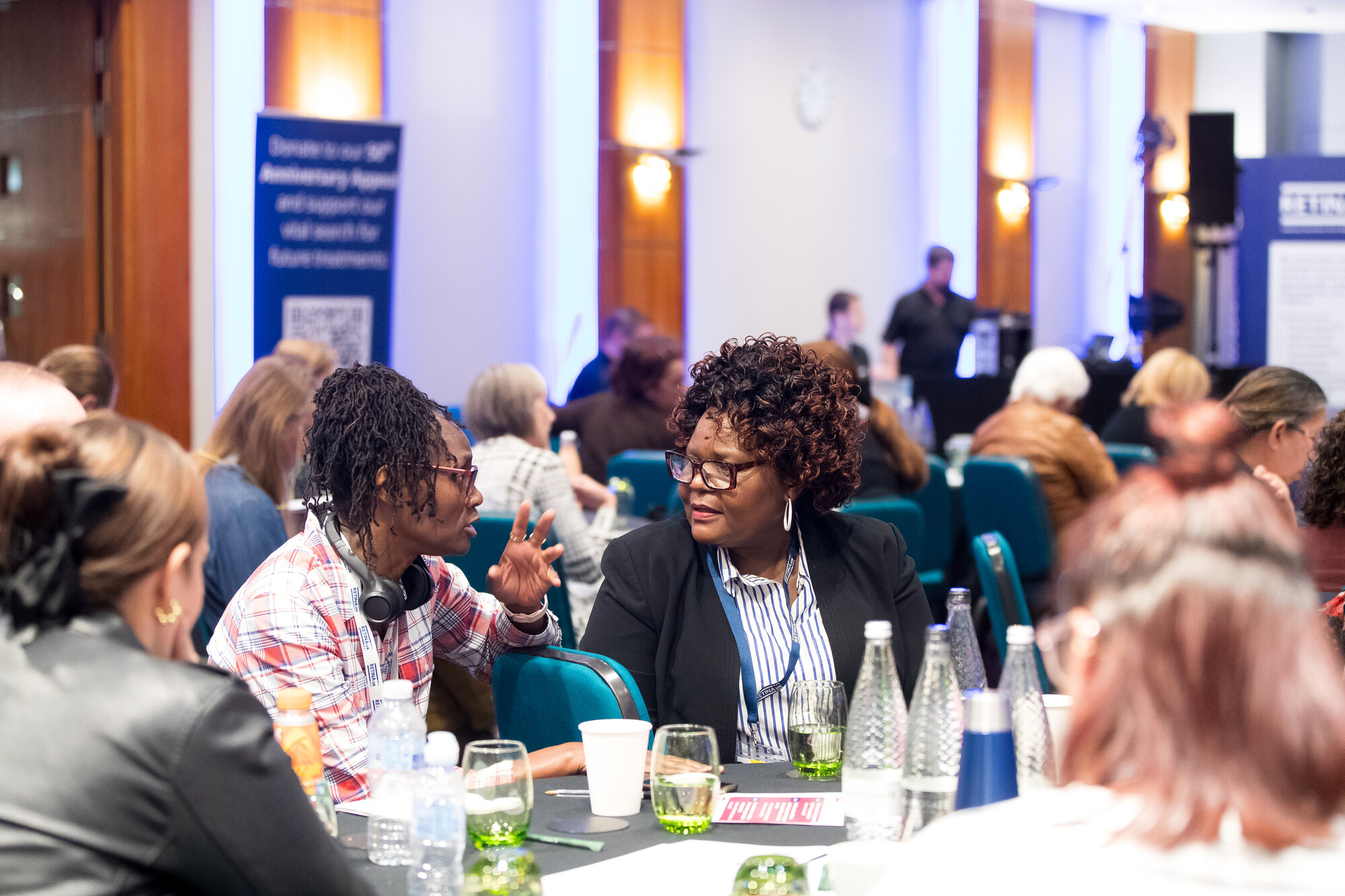 A large group of people seated around round tables at the Retina UK Professionals' Conference 2025